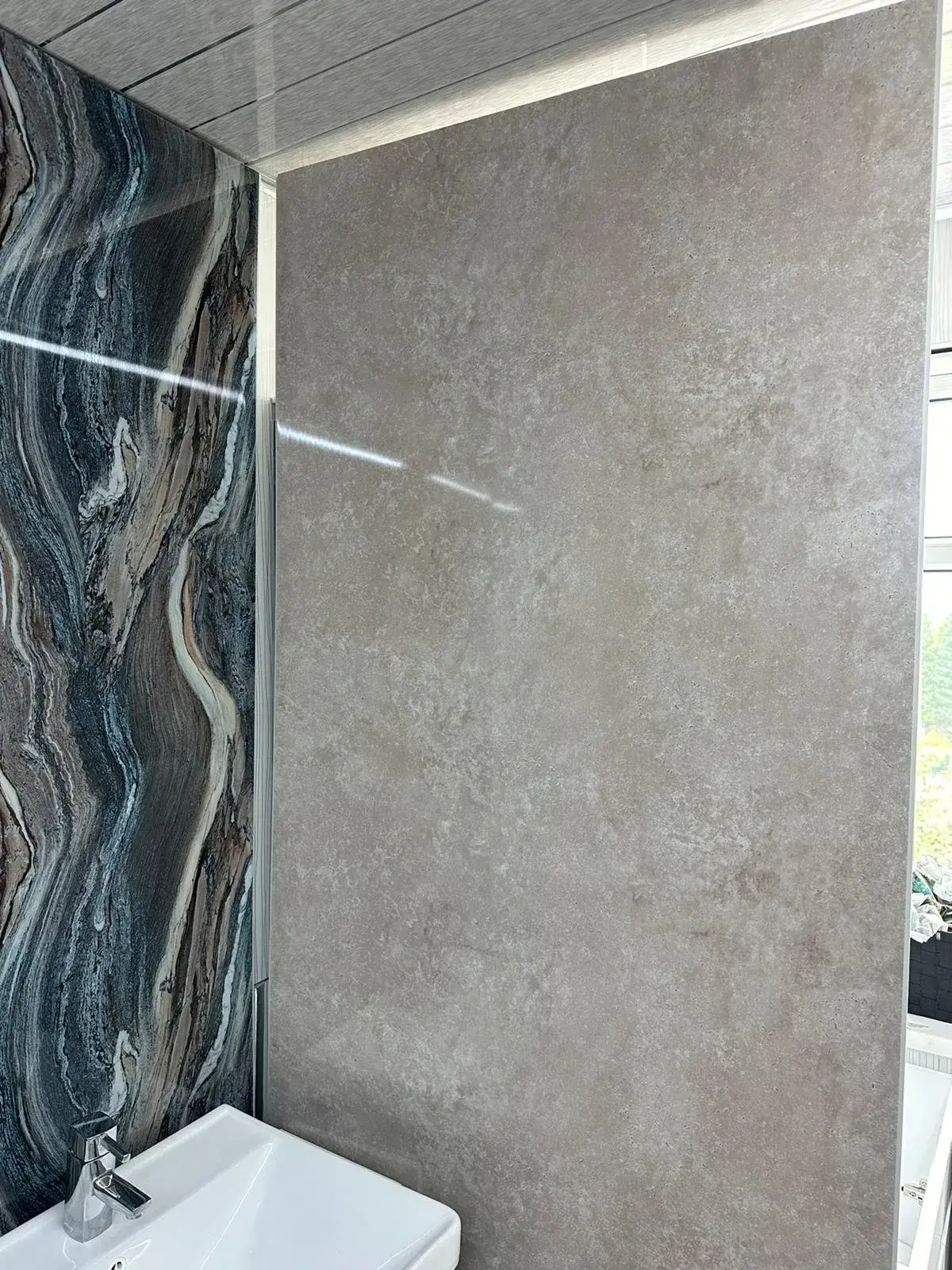 a bathroom with a sink and a marble wall