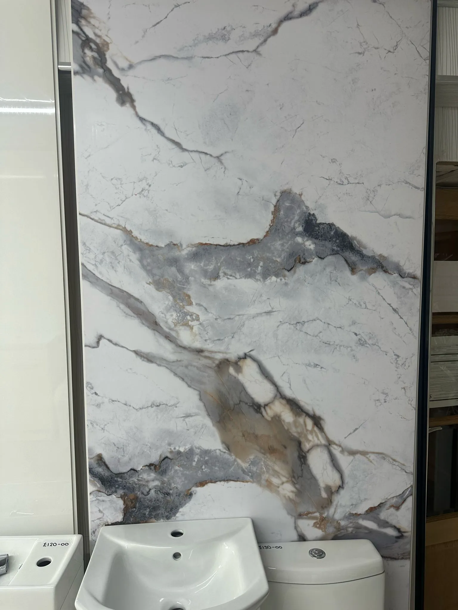 A white toilet sitting next to a white sink.