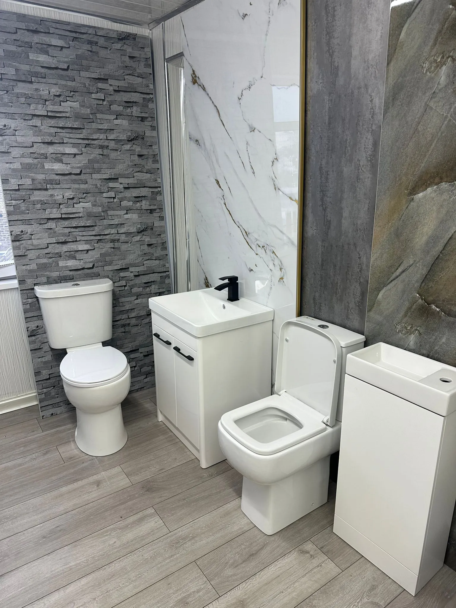 a bathroom with two toilets, a sink, and a mirror