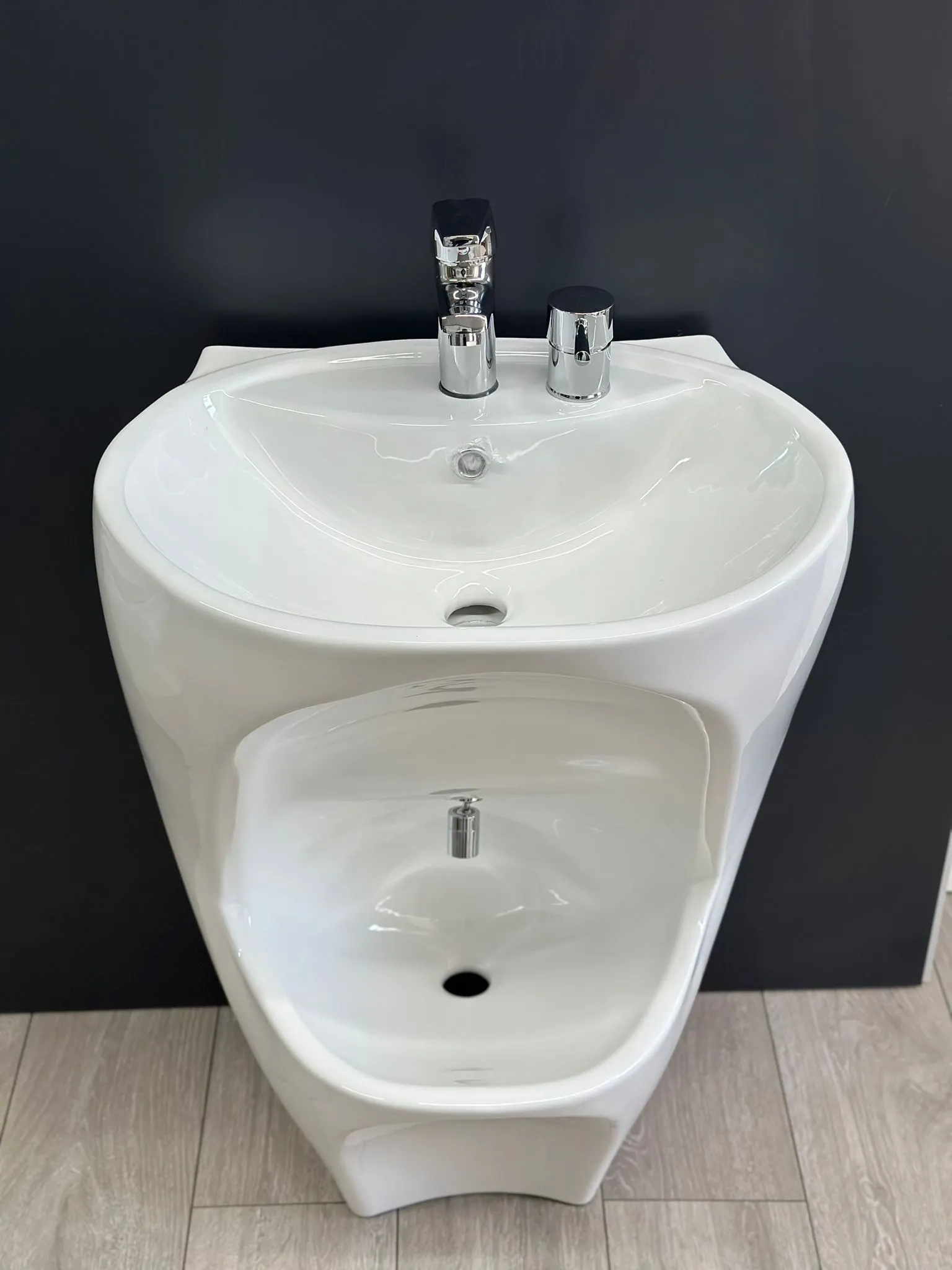 A white bathroom sink sitting on top of a wooden floor.
